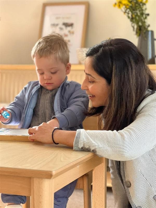 Khyati guiding a child through a Montessori activity