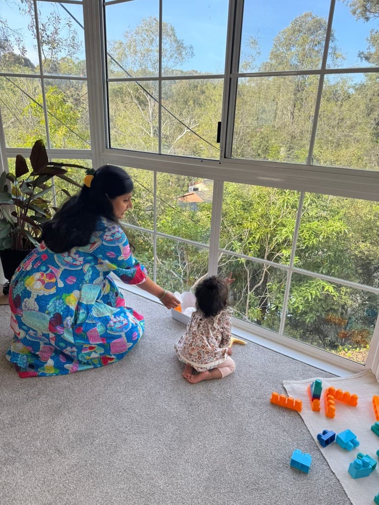 Parent and child playing by the window